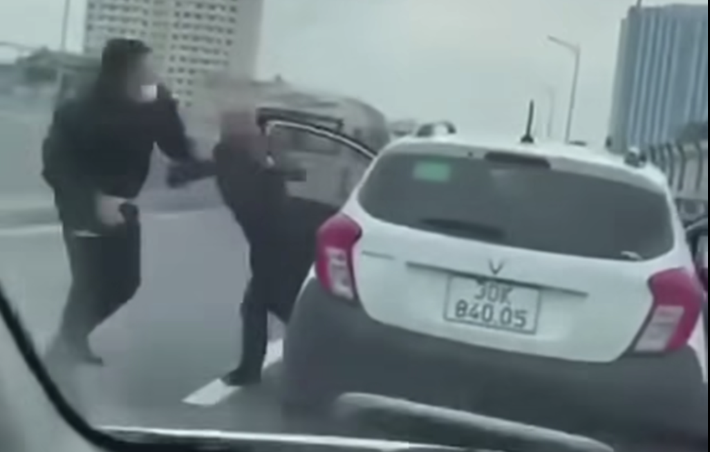 Người trên ô tô xuống xe đánh nhau với 2 người đi xe máy. (Ảnh cắt từ clip)