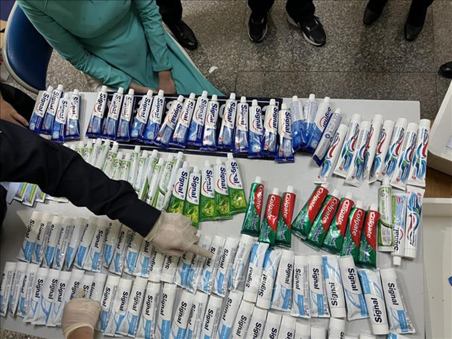 Kiểm đếm lô hàng chất ma túy được giấu trong những tuýp kem đánh răng bị thu giữ từ hành lý của 4 tiếp viên hàng không. Ảnh: TTXVN