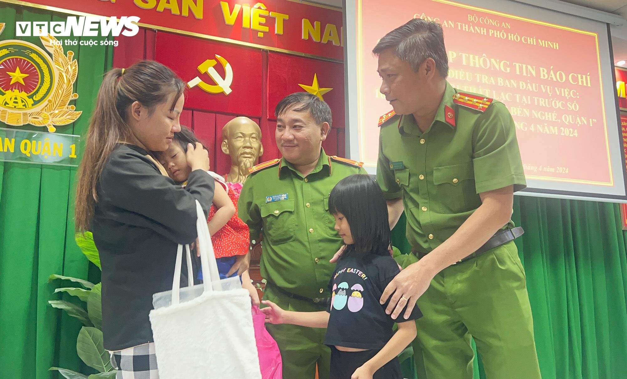 Công an Quận 1, TP.HCM trao trả 2 bé gái cho mẹ là chị Nguyễn Thị Chi. (Ảnh: Hoàng Thọ)