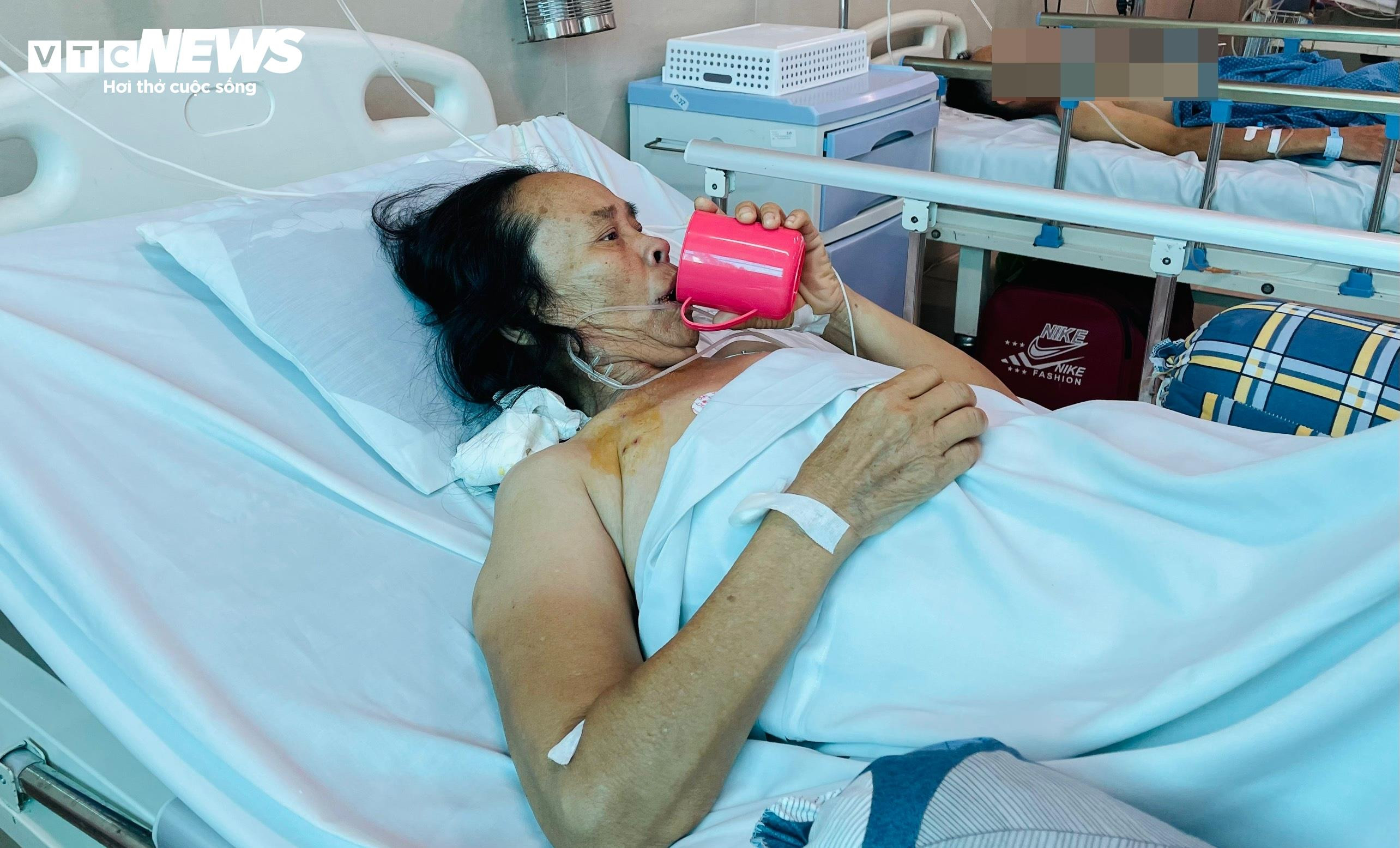 Bà Lan khó khăn uống từng ngụm nước. (Ảnh: Như Loan)