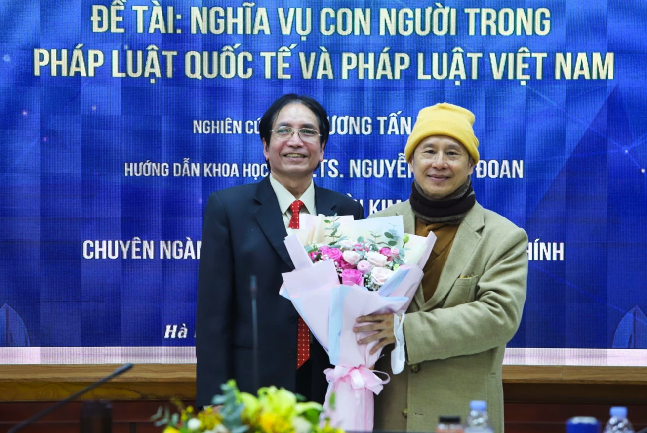 GS Nguyễn Minh Đoan (trái) và ông Thích Chân Quang trong buổi bảo vệ luận án tiến sĩ. (Ảnh: HLU)