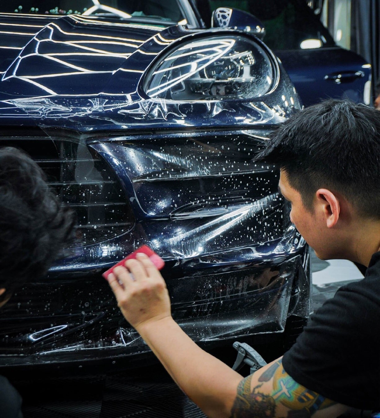 Kỹ thuật viên đang thi công phim bảo vệ sơn xe (PPF).