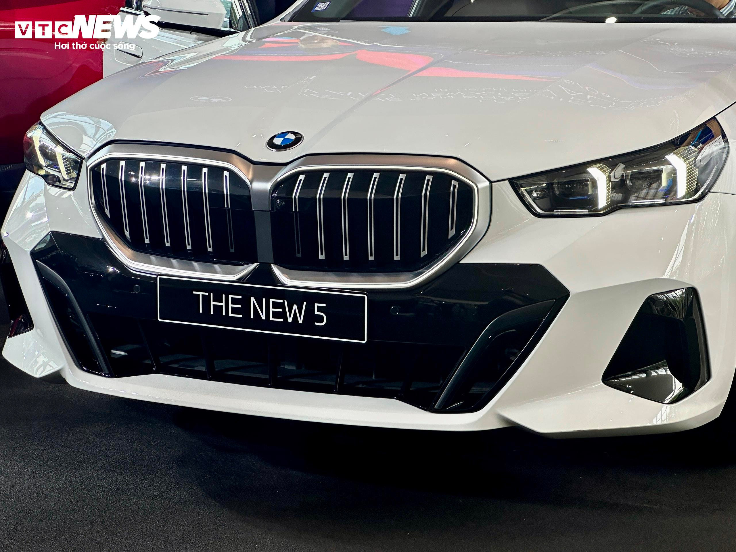 Cản trước của BMW 5 Series hoàn toàn mới nổi bật với cụm đèn pha đôi, cùng lưới tản nhiệt hình “quả thận” đặc trưng được thiết kế cách tân. Dải đèn LED định vị ban ngày kiêm đèn báo rẽ dạng mũi tên đặt theo chiều dọc tạo điểm nhấn thể thao, mạnh mẽ. Lưới tản nhiệt của BMW 5 Series hoàn toàn mới được thiết kế nhô ra phía trước nhiều hơn, viền rộng và mạ chrome sang trọng. (Ảnh: Mạnh Hùng)