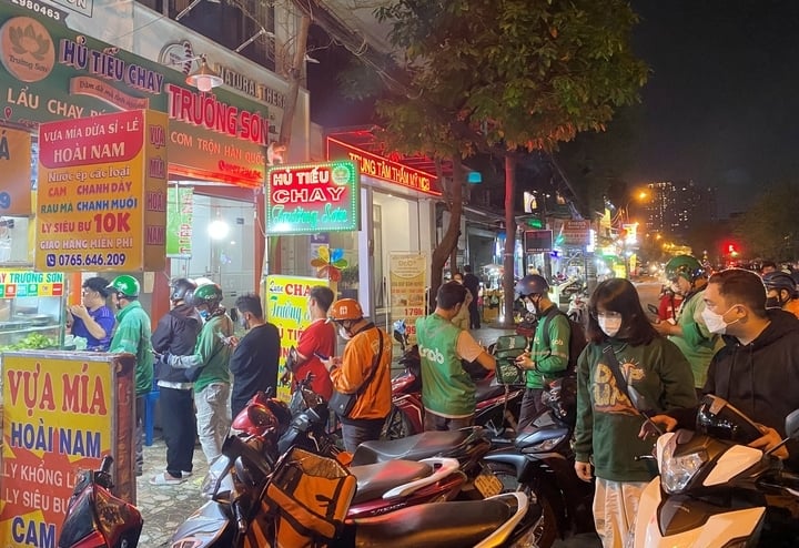 Các hàng quán bán ở đô thị lớn luôn đông nghẹt shipper chờ mua đồ ăn cho khách. (Ảnh: Đ. Việt)