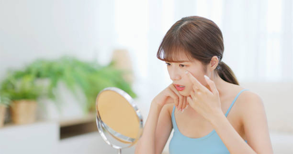 Sờ tay lên mặt hoặc nặn mụn thường xuyên cũng khiến lỗ chân lông to thêm. (Ảnh: Istock)