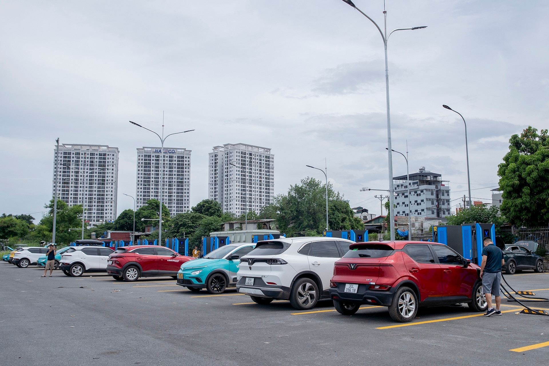 Trạm sạc này tọa lạc tại bãi đỗ xe Minh Khai (đường Cầu Diễn, quận Nam Từ Liêm). Đây là trục đường huyết mạch, ở cửa ngõ Thủ đô, kết nối với quốc lộ 32 đi các tỉnh Tây Bắc. Tại đây, V-Green lắp đặt 42 trụ sạc công suất 120 kW, có khả năng đáp ứng nhu cầu sạc cùng lúc của 84 xe điện VinFast khác nhau.