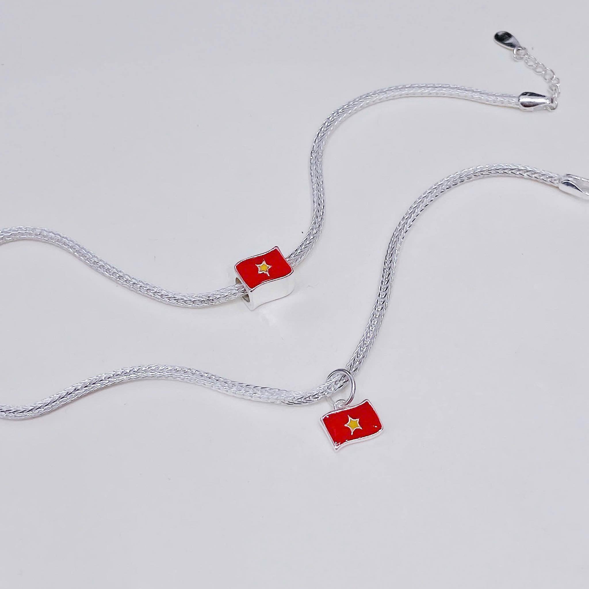 Những chiếc lắc tay, dây chuyền charm cờ nhỏ xinh được nhiều bạn trẻ yêu thích. (Ảnh: Trang sức Vàng Bạc TANA)