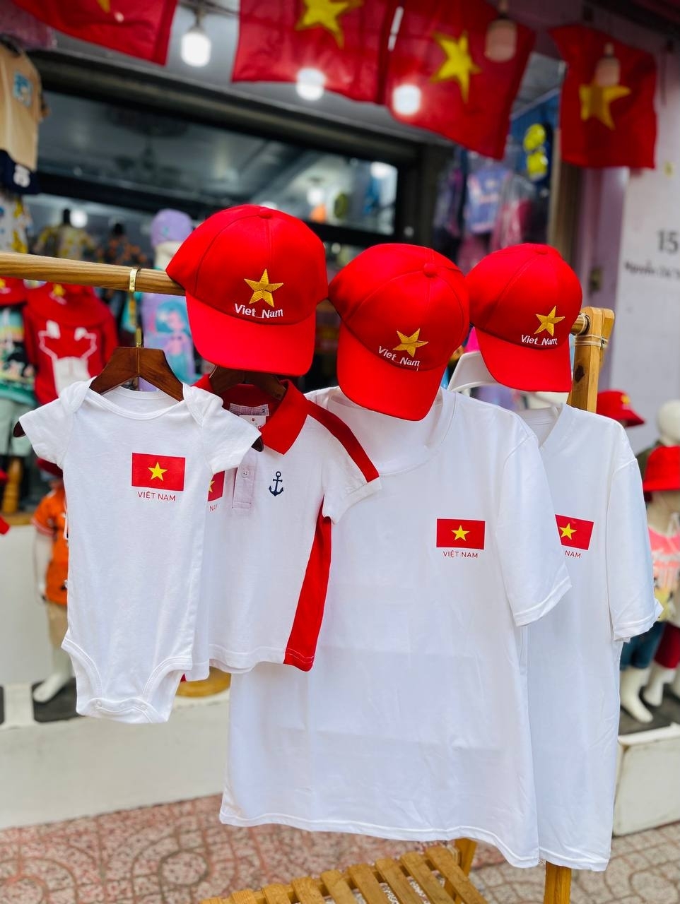Giá áo phông in hình cờ đỏ sao vàng khá đa dạng, từ vài chục nghìn đến hàng trăm nghìn đồng. Trong đó, áo phông cotton thoáng mát, giá từ 100.000 - 200.000 đồng được khách chuộng hơn cả. (Ảnh: Fosig)