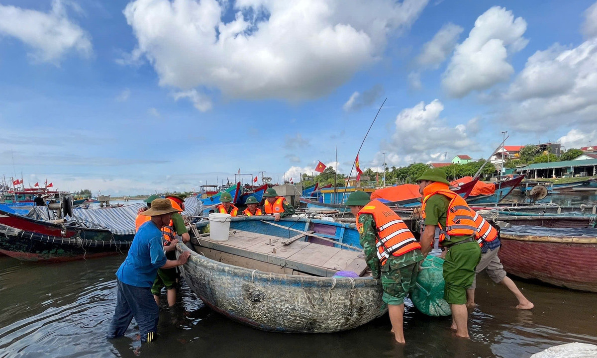 Cán bộ, chiến sĩ Biên phòng, Công an tỉnh Quảng Trị hỗ trợ đưa thuyền vào bờ tránh trú bão số 5. (Ảnh: Báo Nhân Dân)