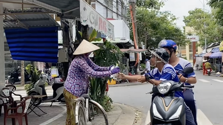Hai bạn nam trong nhóm đi tặng suất ăn.