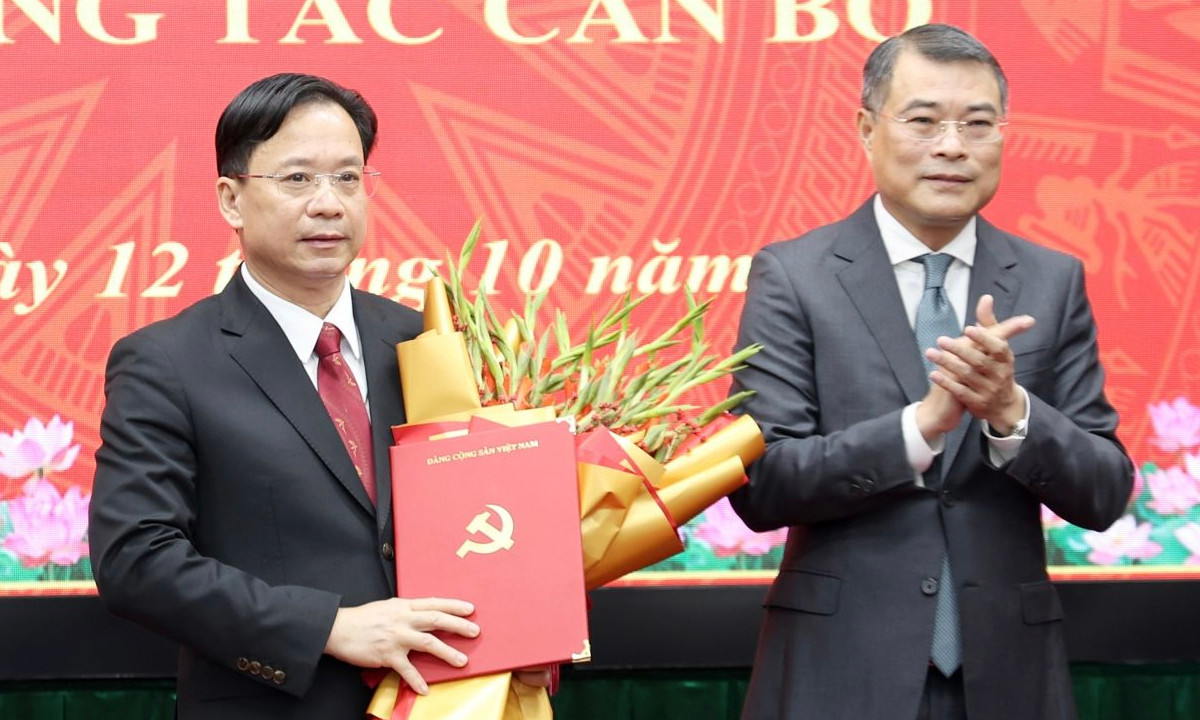 Trưởng ban Tổ chức Trung ương Lê Minh Hưng trao quyết định và tặng hoa chúc mừng ông Hoàng Văn Nghiệm. (Ảnh: Báo Sơn La)