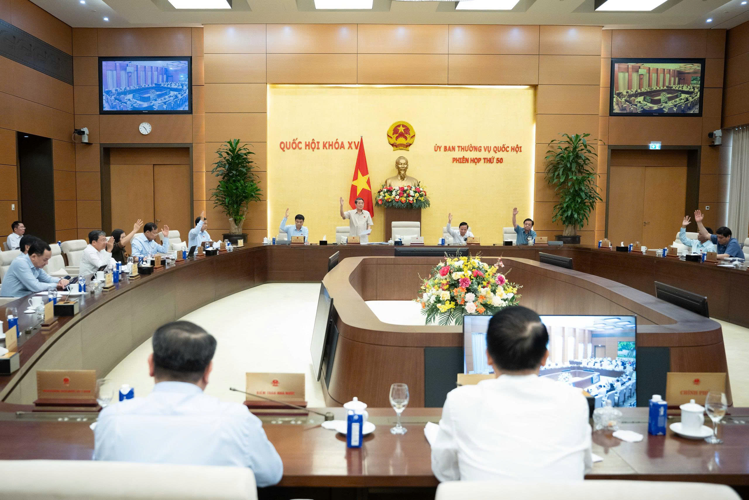Các Ủy viên Ủy ban Thường vụ Quốc hội biểu quyết thông qua Nghị quyết.