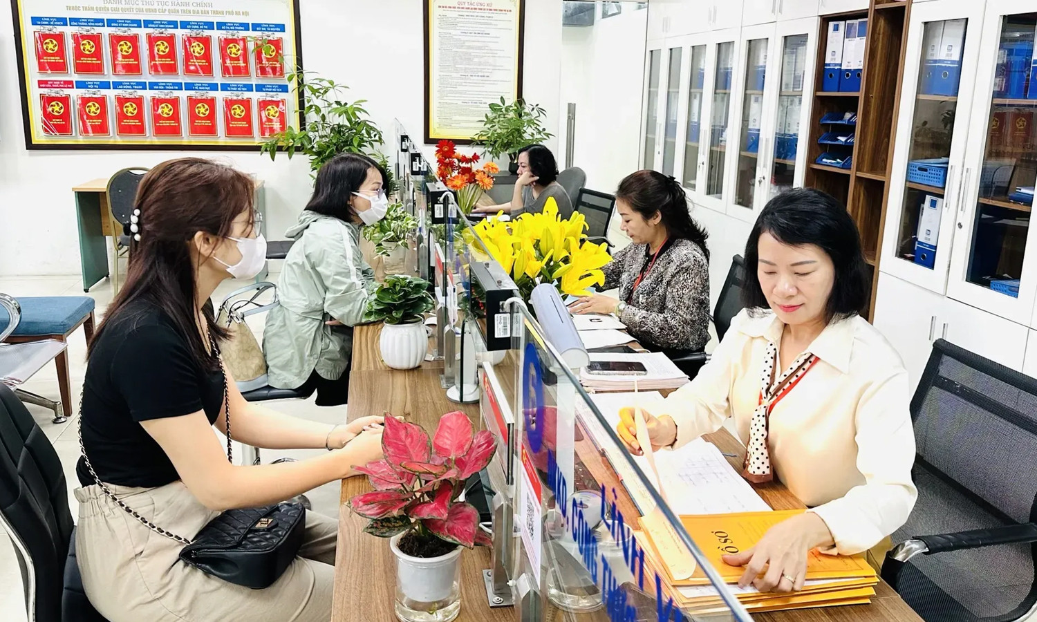 Công chức phường ở Hà Nội hỗ trợ người dân giải quyết thủ tục hành chính.