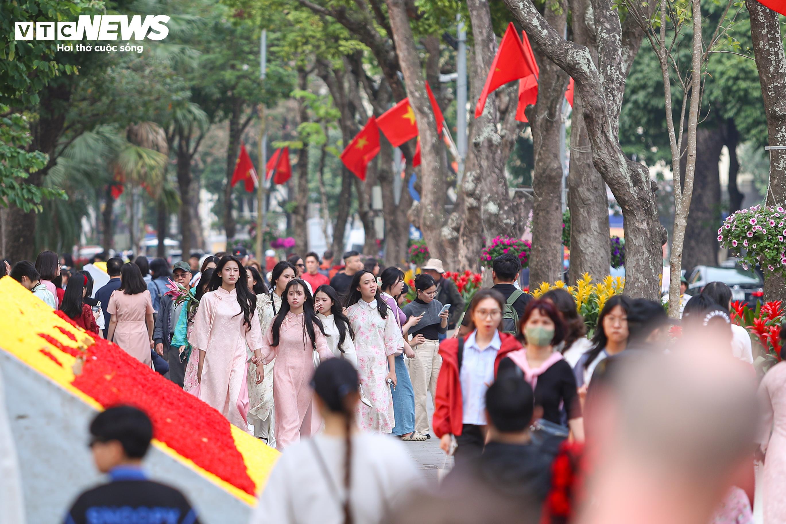 Tại khu vực Hồ Gươm, hàng trăm cô gái diện áo dài rực rỡ, tranh thủ lưu lại những khoảnh khắc trước thềm năm mới.