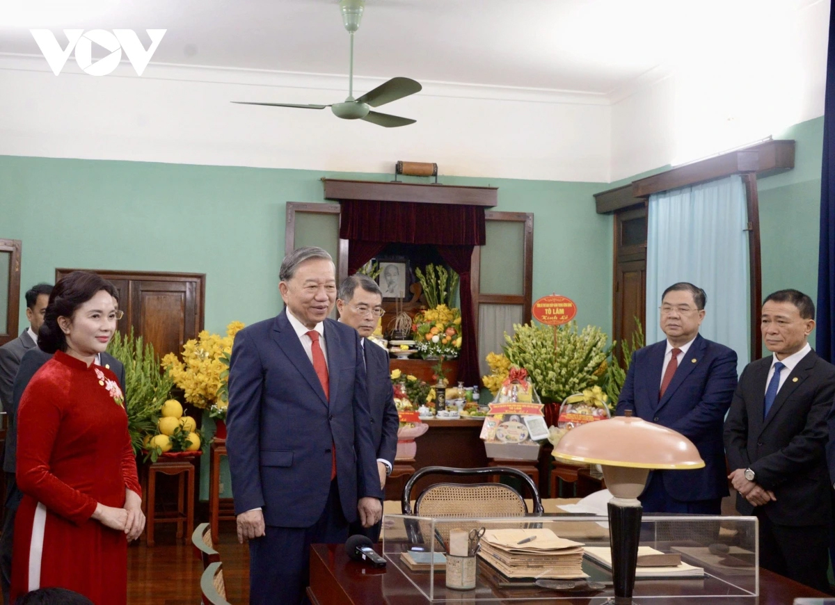 Tổng Bí thư Tô Lâm nghe nhân viên khu di tích giới thiệu về những kỷ vật của Bác Hồ.