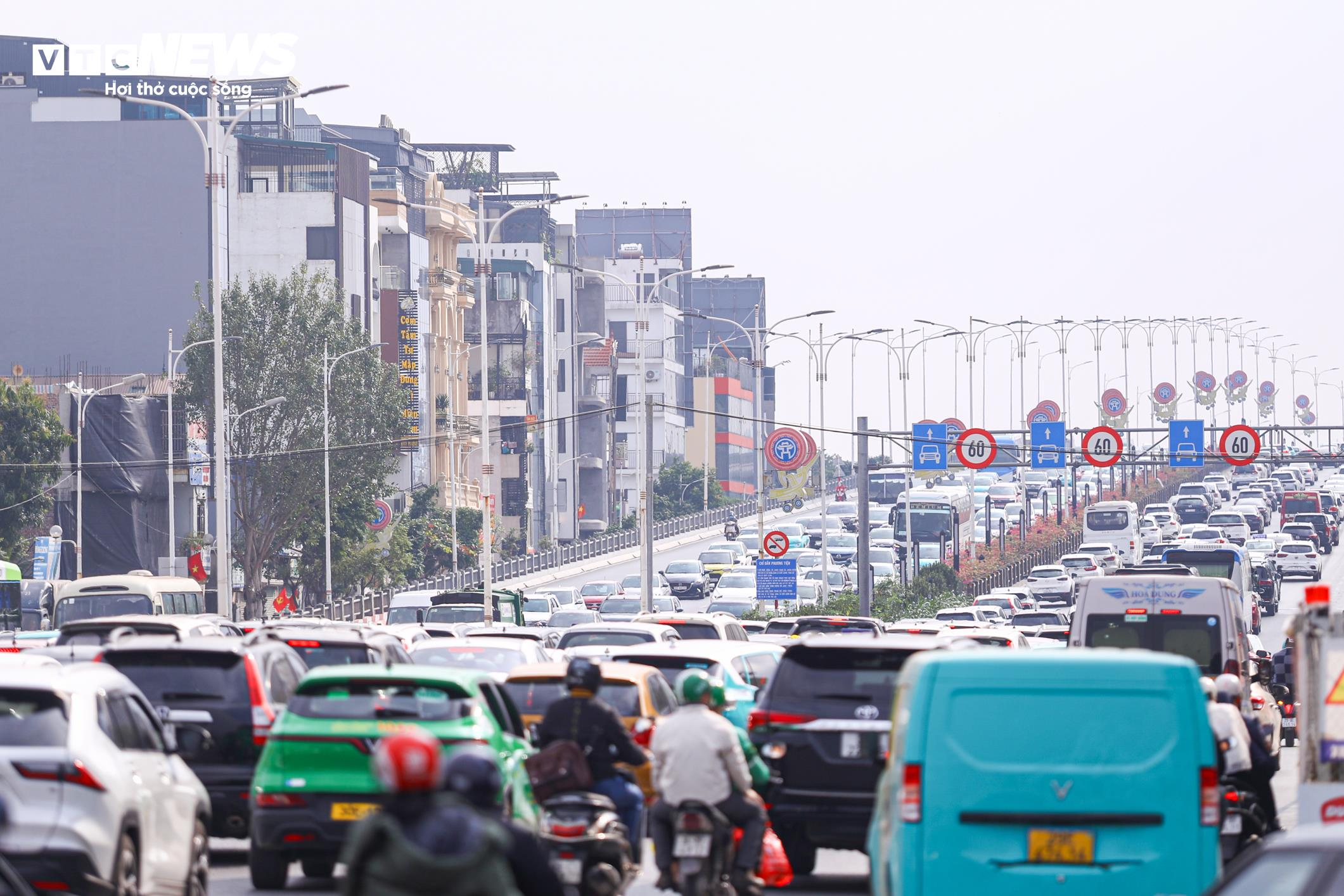 Giao thông cũng ùn ứ, phương tiện di chuyển rất chậm trên hướng Vành đai 2 lên cầu Vĩnh Tuy (Hà Nội) chiều 21/2.