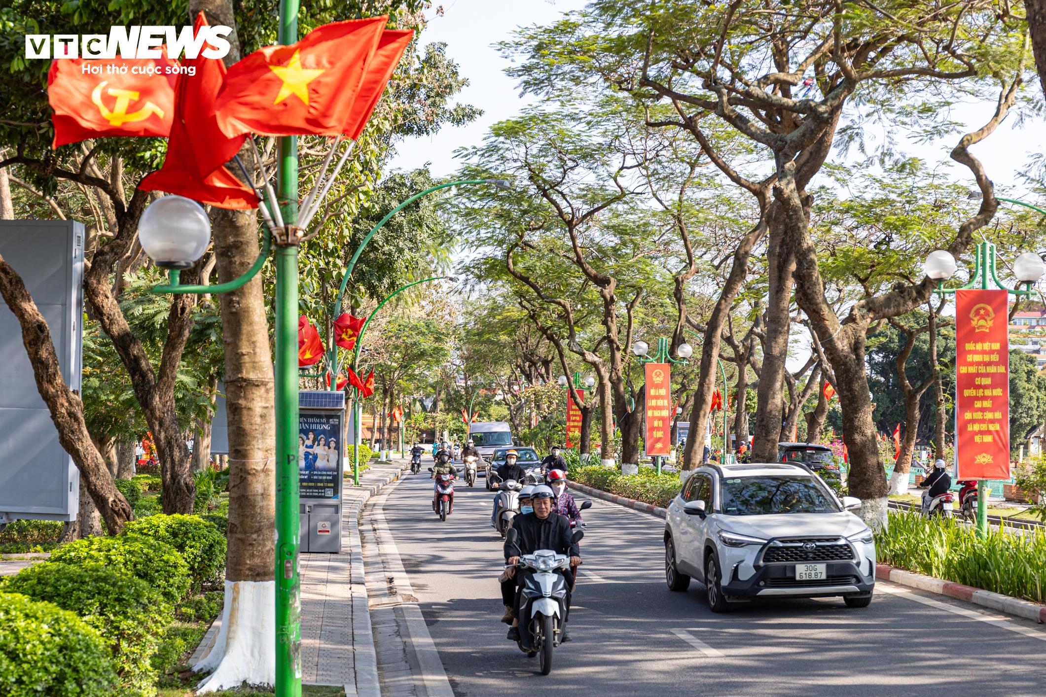 Những ngày đầu tháng 3, nhiều tuyến phố Hà Nội được trang hoàng rực rỡ với cờ Tổ quốc, cờ Đảng cùng hệ thống pano, băng rôn tuyên truyền. Không khí hướng tới cuộc bầu cử đại biểu Quốc hội khóa XVI và đại biểu HĐND các cấp nhiệm kỳ 2026 - 2031 đang lan tỏa rộng khắp, từ khu vực trung tâm thành phố đến các xã ngoại thành.