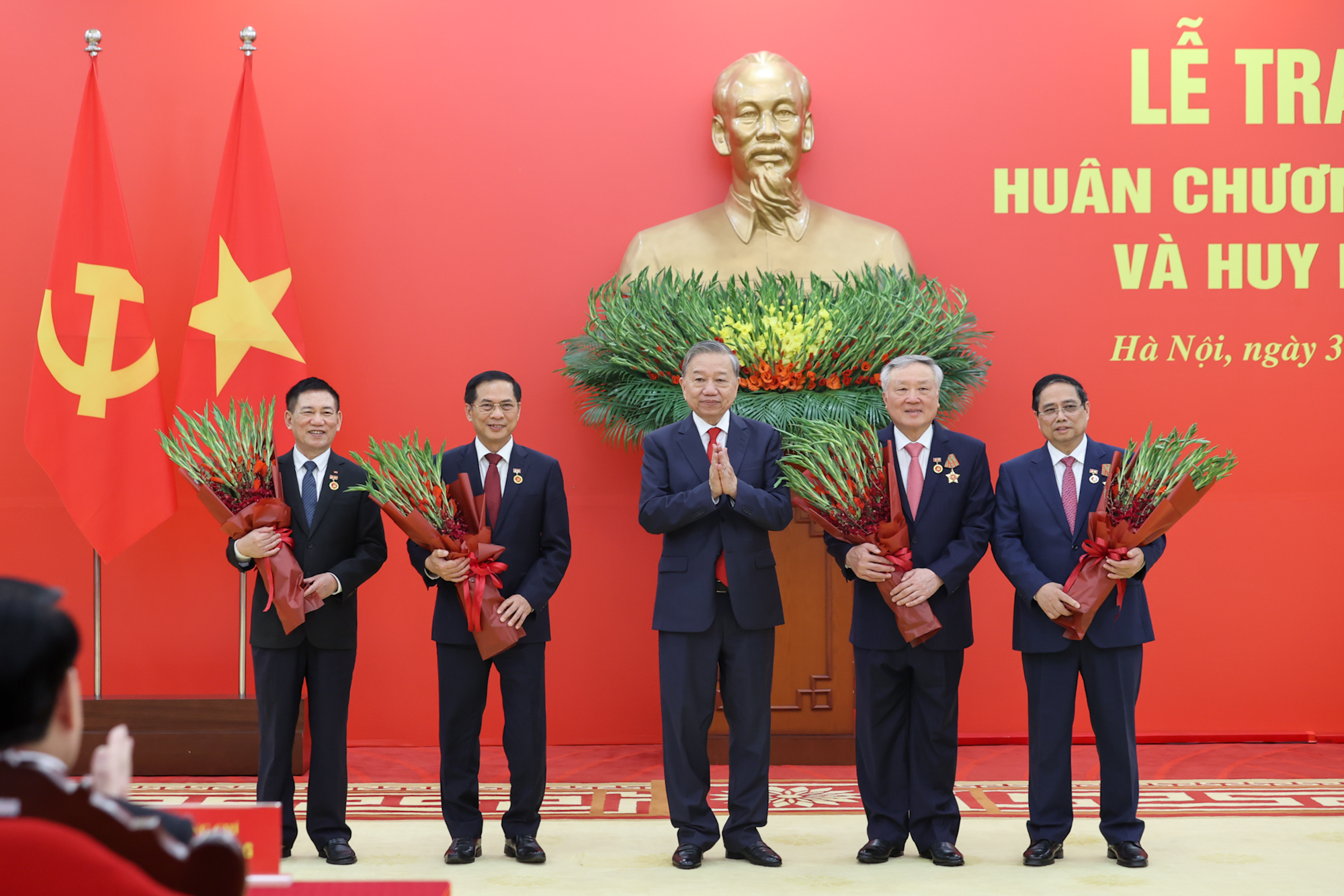 Tổng Bí thư Tô Lâm tặng hoa chúc mừng các đồng chí được nhận Huy hiệu Đảng. (Ảnh: VGP)