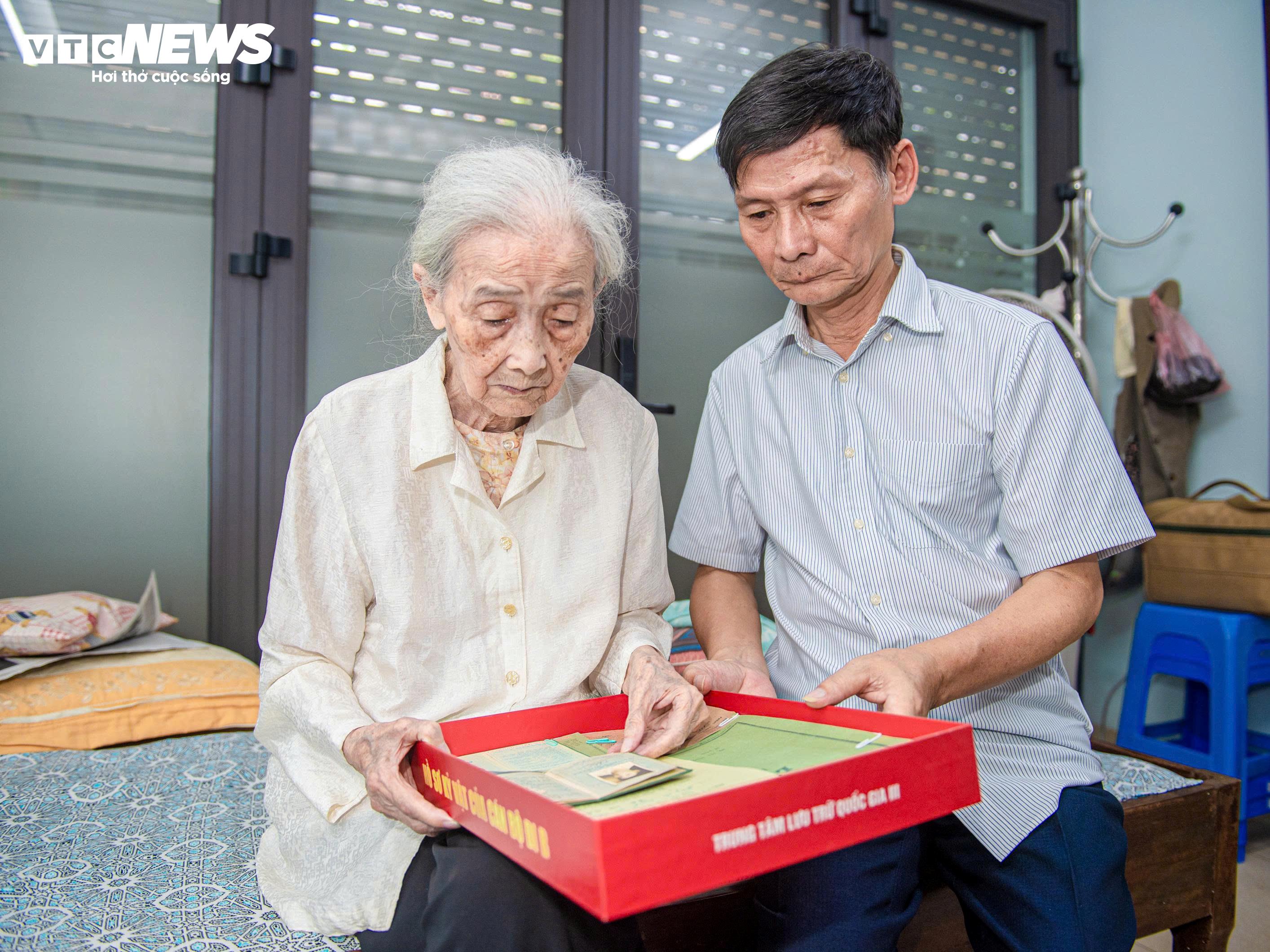 Bà Bùi Vi Anh cùng con trai Nguyễn An Hải lật mở từng trang hồ sơ của chồng - liệt sĩ Nguyễn Đức Châu.